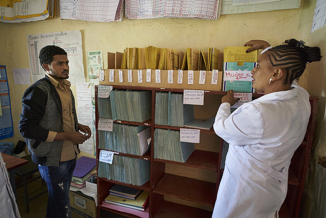 Mekdes explains the Tickler file box to Tesfu, a zonal health department employee.