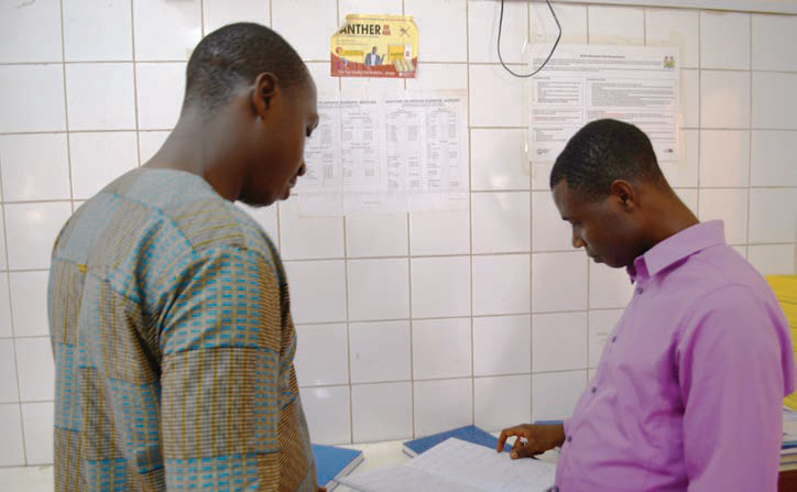 Photo of two men looking over papers in a clinic.