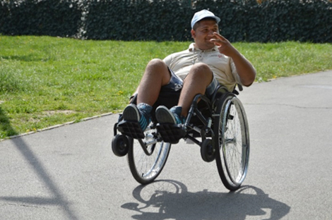 Photo of Marius popping a wheelie in his wheelchair.