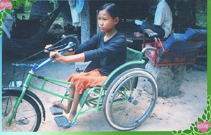 Photo of Hout Thoeung in a wheelchair modified into a tricycle