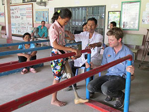 Photo of Sum Srey Norng learning to walk with her prosthetic