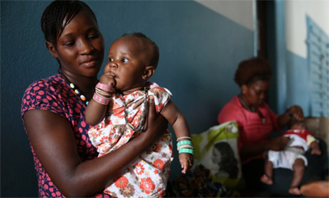 Photo of a woman holding an infant at a clinic.