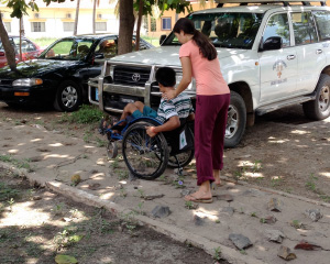 Photo of Hoeun Chan being pushed outside in a wheelchair