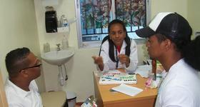 Photo of a client receiving services at Clinica de Familia La Romana with health providers Riqui Rosario and Dr. Wendy Galvez. Photo: Carol Brito